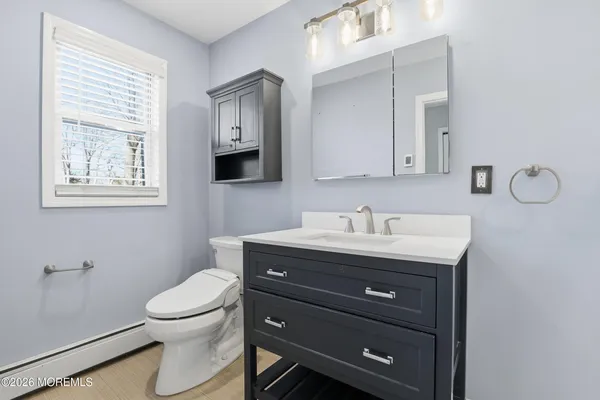 a bathroom with a granite countertop toilet sink and mirror