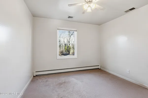 an empty room with a window and a fan