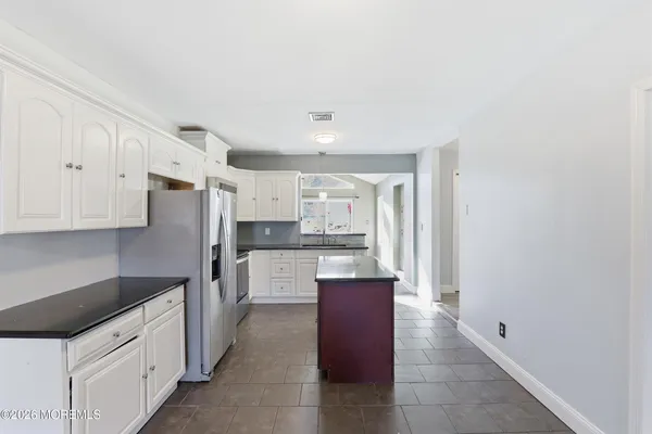a kitchen with stainless steel appliances granite countertop a refrigerator and a sink