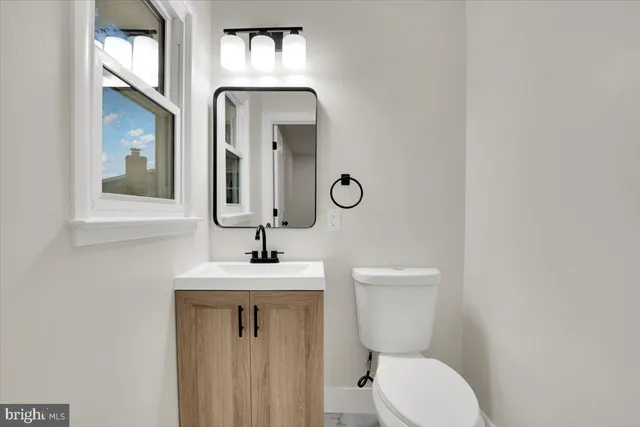 a bathroom with a toilet sink and mirror