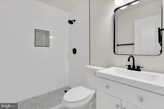 a bathroom with a toilet a sink and mirror