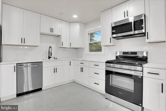a kitchen with cabinets stainless steel appliances and sink