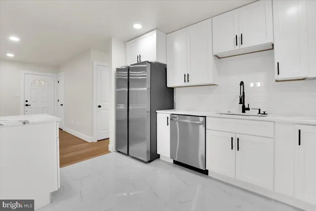 a kitchen with white cabinets and white appliances