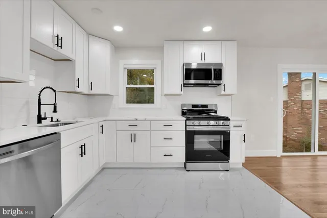 a kitchen with granite countertop a sink stainless steel appliances and cabinets
