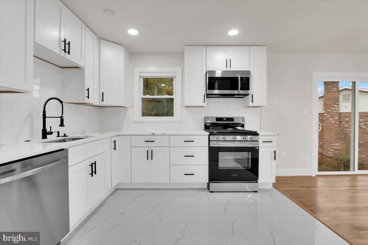 14624 Danville Road Woodbridge, VA 22193 - Photo 22 of 32 a kitchen with granite countertop a sink stainless steel appliances and cabinets