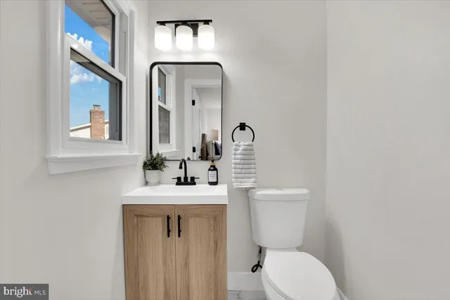 a bathroom with a toilet sink and mirror