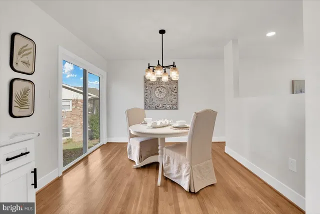 a dining room with furniture a chandelier and wooden floor