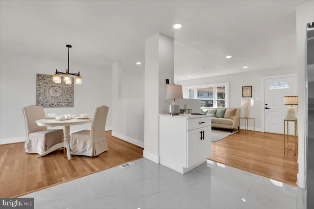 a view of a dining room and livingroom with furniture wooden floor a chandelier