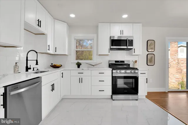 a kitchen with stainless steel appliances a stove sink and microwave