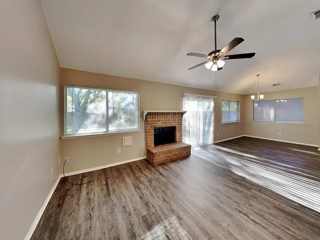 a view of empty room with wooden floor and fireplace