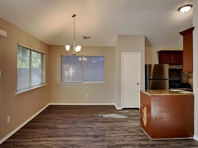 a view of a kitchen with wooden floor and electronic appliances