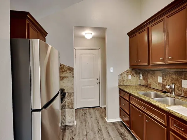 a kitchen with stainless steel appliances granite countertop a refrigerator and a sink