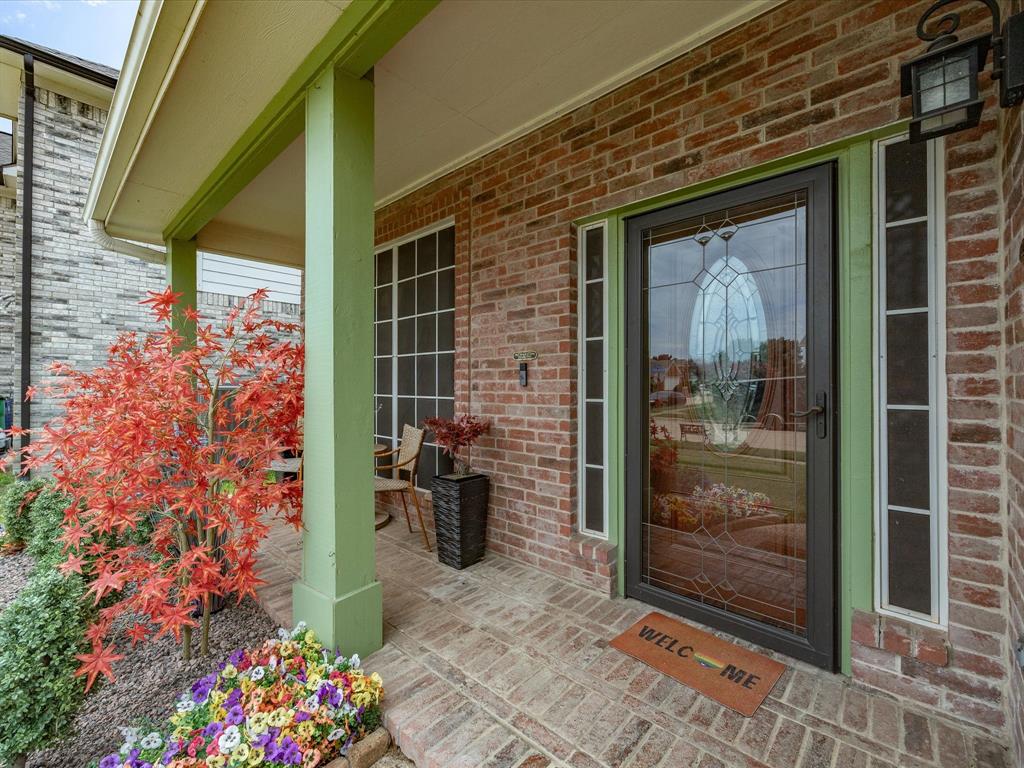 4008 Falcon Ridge Drive Haltom City, TX 76137 - Photo 3 of 40 Brick facade entryway with a decorative glass front door, two sidelight windows, and an overhead transom window