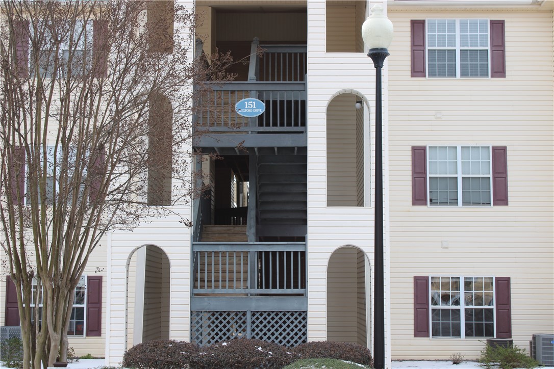 This charming multi-story building features a welcoming exterior, with stairs and arched entryways.