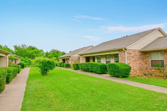 a front view of a house with a yard and green space