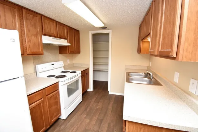 a kitchen with a sink a stove and cabinets