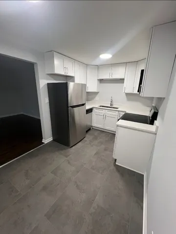 a kitchen with a refrigerator sink and cabinets