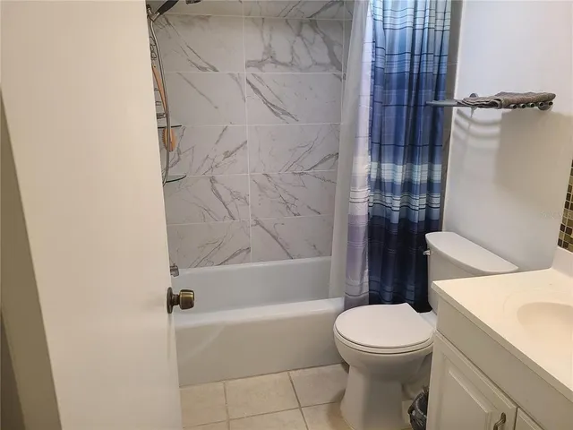 a white toilet sitting next to a bath tub and a shower