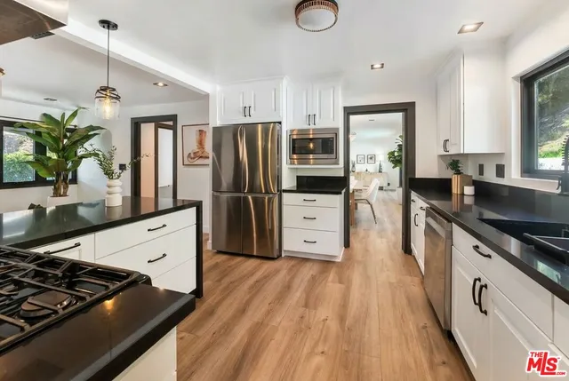 a kitchen with stainless steel appliances a sink stove and refrigerator