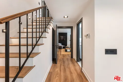 a view of a hallway with wooden floor and stairs