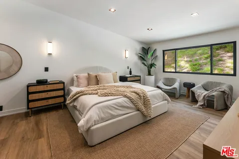 a spacious bedroom with a bed and a large window