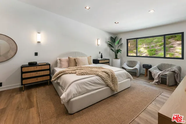 a spacious bedroom with a bed and a large window