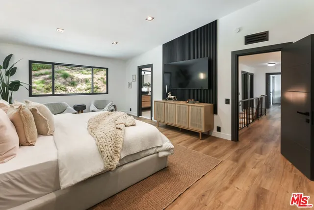 a spacious bedroom with a large bed and a flat screen tv