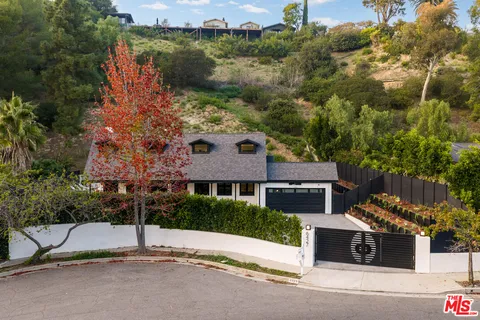 a view of a house with a yard and large tree