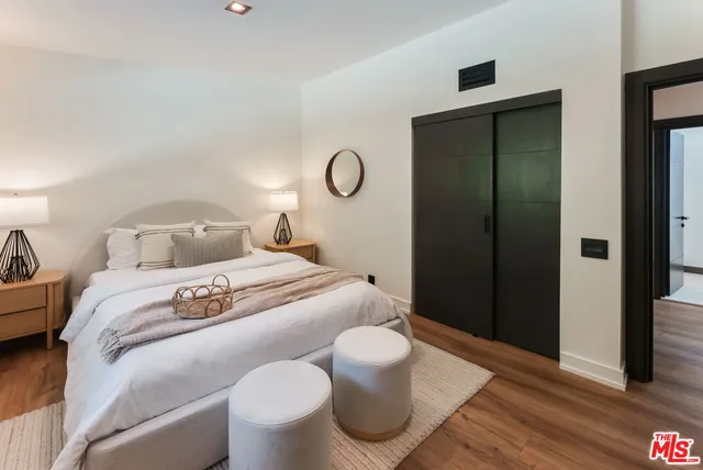 a bedroom with a bed and wooden floor
