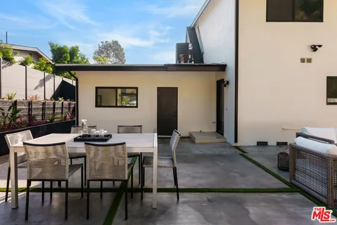 a view of a patio with a dining table and chairs with wooden floor