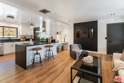 a living room with furniture and kitchen view