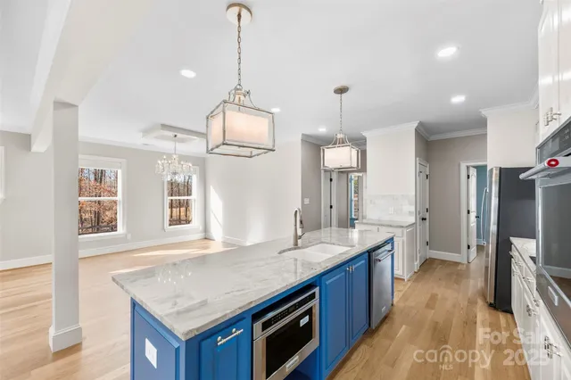a kitchen with granite countertop a sink a counter top space and stainless steel appliances