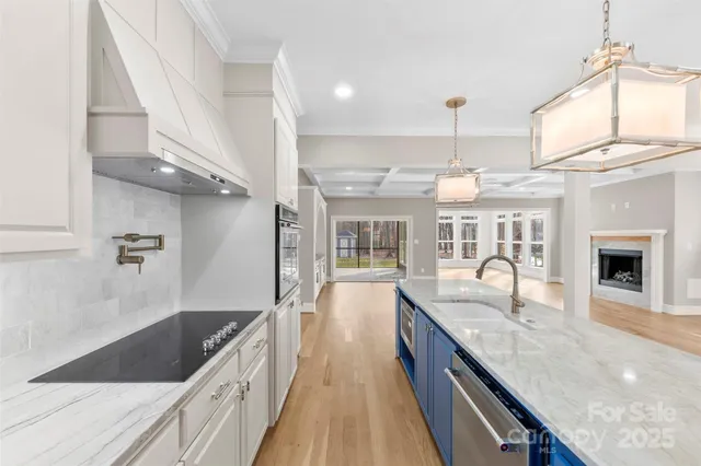 a large kitchen with granite countertop a large counter top a sink stainless steel appliances and cabinets