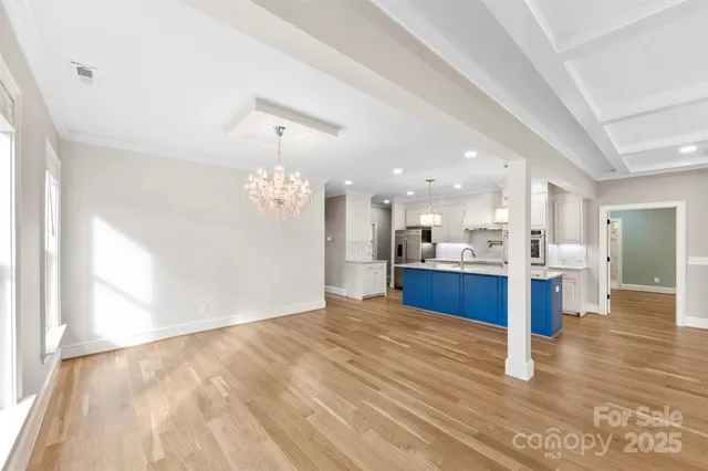 a open kitchen with kitchen island a sink dishwasher a stove and a refrigerator with wooden floor