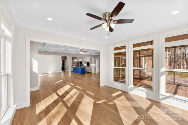 a view of a hallway with wooden floor and windows