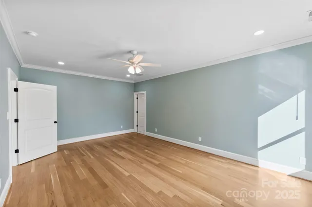 a view of an empty room with a chandelier fan