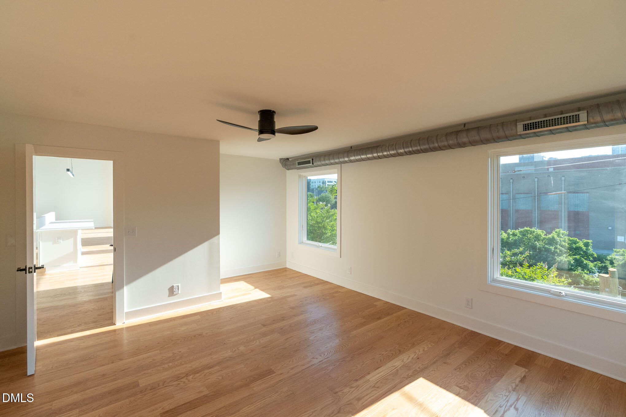 400 East Martin Street, Unit A Raleigh, NC 27601 - Photo 12 of 29 a view of an empty room with wooden floor and a window