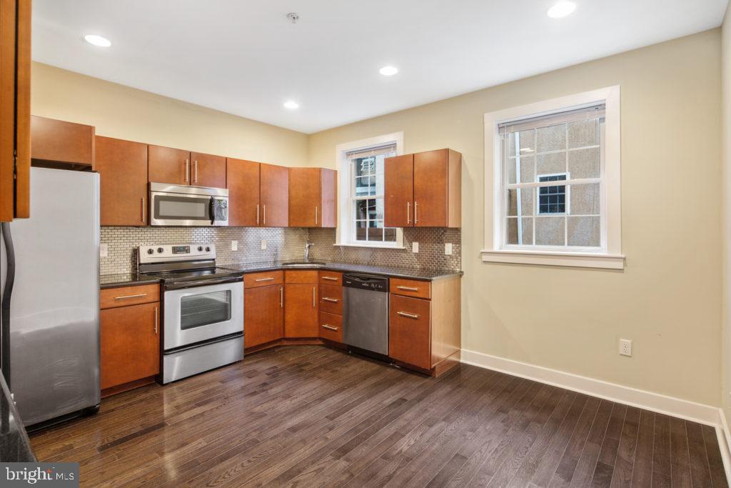 2614 Webster Street, Unit A Philadelphia, PA 19146 - Photo 3 of 12 a kitchen with granite countertop a refrigerator and a stove top oven