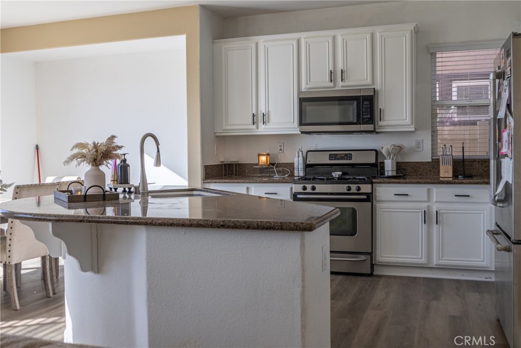 1639 Rigel Street Beaumont, CA 92223 - Photo 3 of 16 a kitchen with stainless steel appliances granite countertop a sink stove and microwave