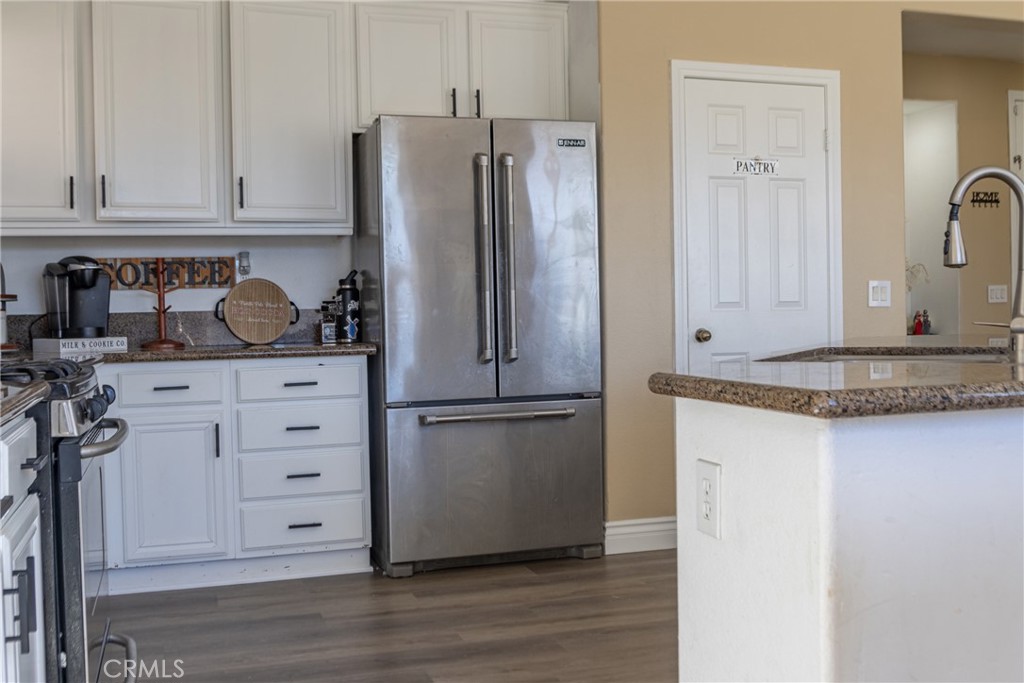 1639 Rigel Street Beaumont, CA 92223 - Photo 5 of 16 a kitchen with granite countertop a refrigerator and a stove