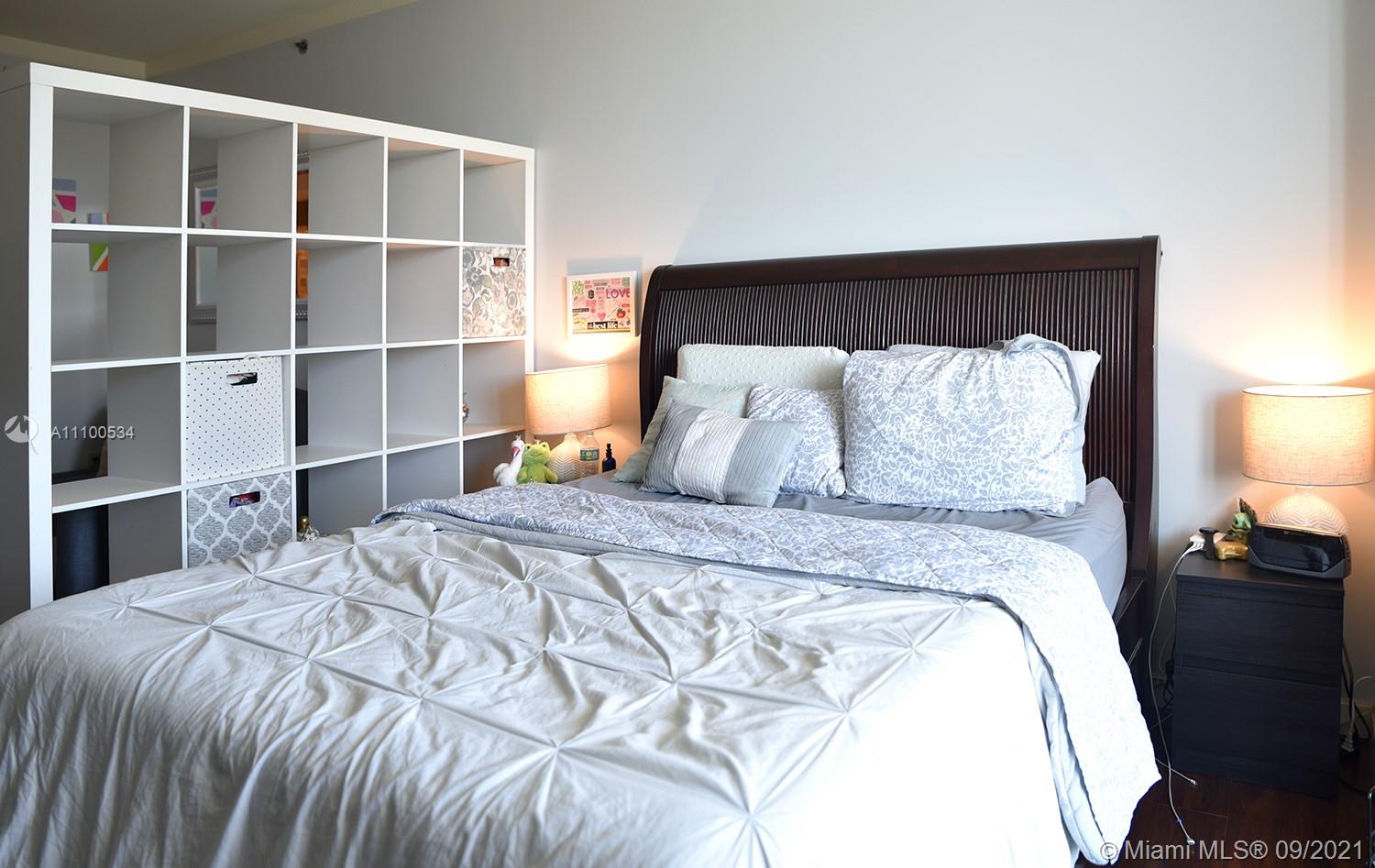 2889 McFarlane Road, Unit 1603 Miami, FL 33133 - Photo 13 of 16 a bedroom with a bed and a lamp