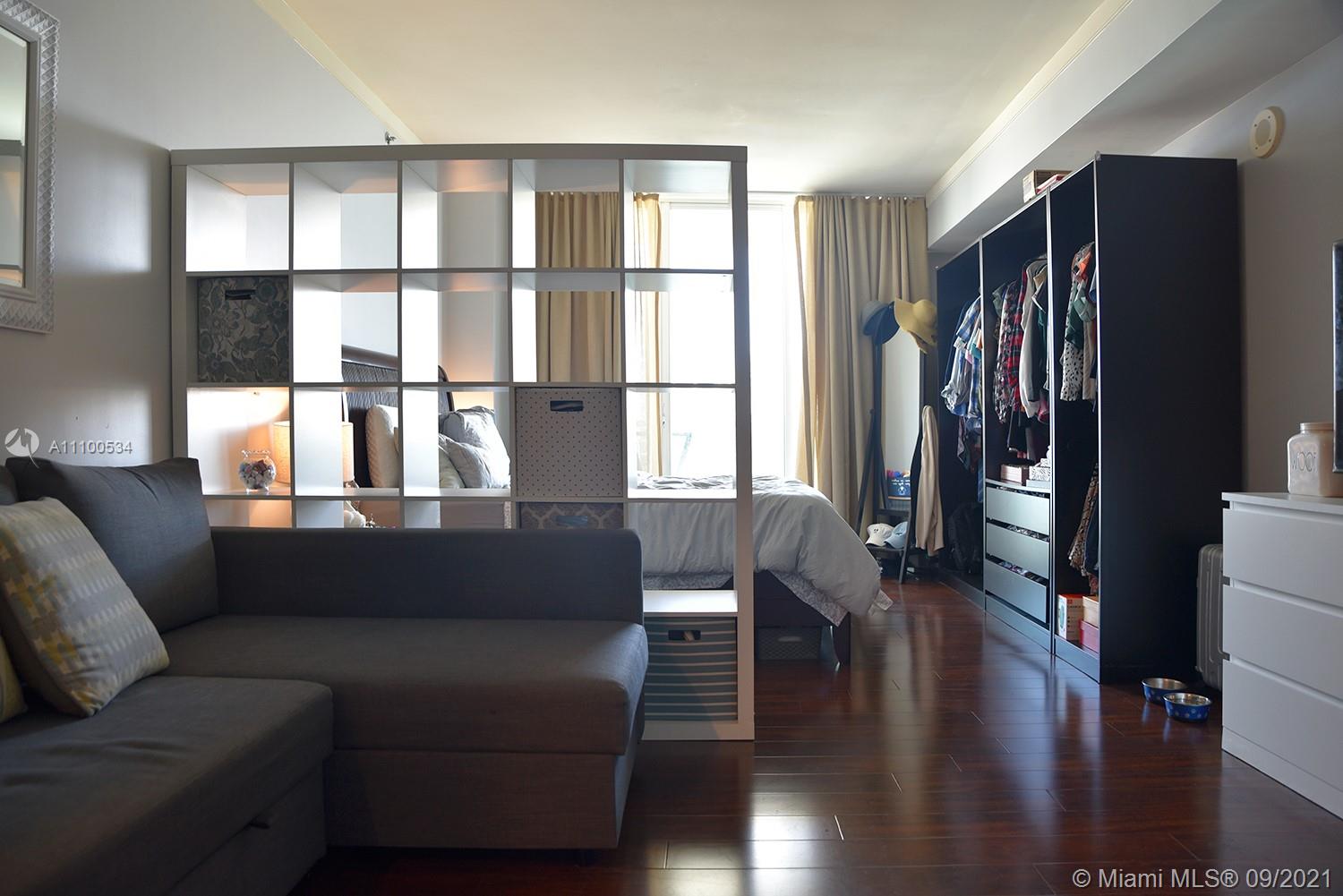 2889 McFarlane Road, Unit 1603 Miami, FL 33133 - Photo 14 of 16 a living room with furniture and wooden floor