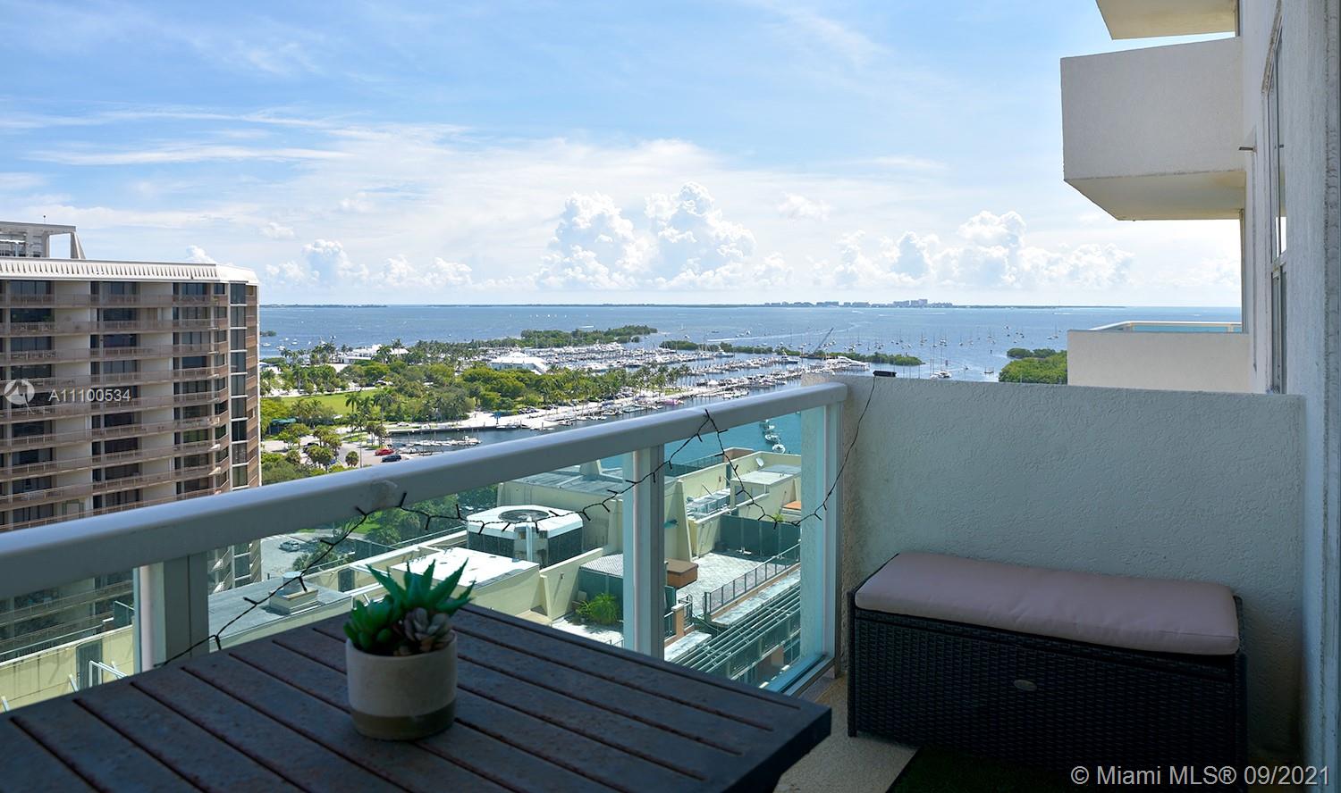 2889 McFarlane Road, Unit 1603 Miami, FL 33133 - Photo 3 of 16 a view of a balcony with wooden floor and outdoor seating