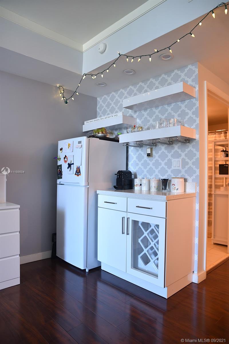 2889 McFarlane Road, Unit 1603 Miami, FL 33133 - Photo 8 of 16 a kitchen with a stove and wooden floor