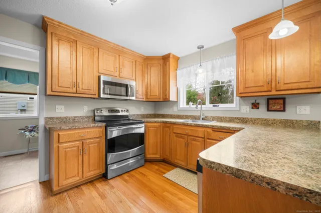 a kitchen with stainless steel appliances granite countertop a stove a sink and a microwave
