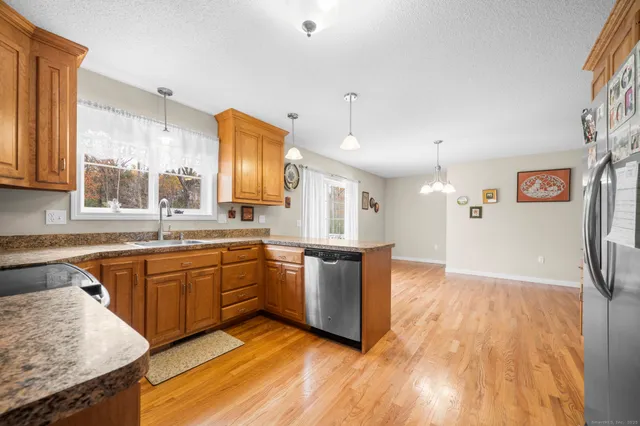 a large kitchen with stainless steel appliances granite countertop a sink and a stove
