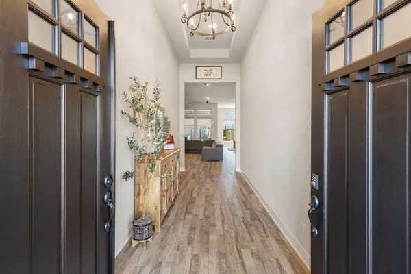 a view of a hallway with a wooden door and a wooden floor