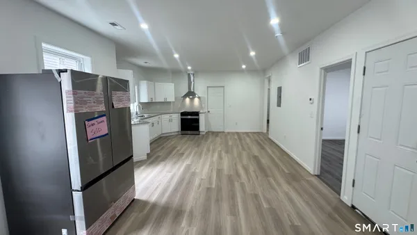 a view of kitchen with stainless steel appliances refrigerator stove microwave and cabinets