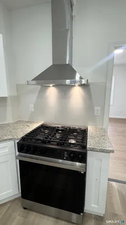 a stove top oven sitting inside of a kitchen