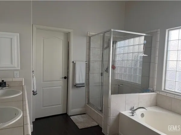 a bathroom with a tub shower sink and mirror